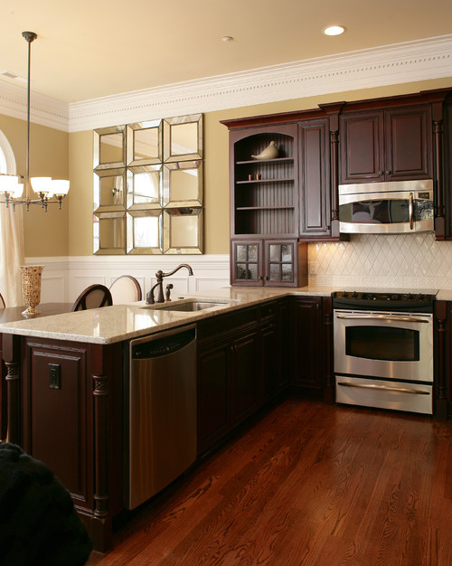 Bianco Romano Countertop with Bombay Stained Cherry Cabinets, Harlequin White Ceramic Backsplash, Stainless Steel Appliance and English Chestnut Stained Oak Flooring.